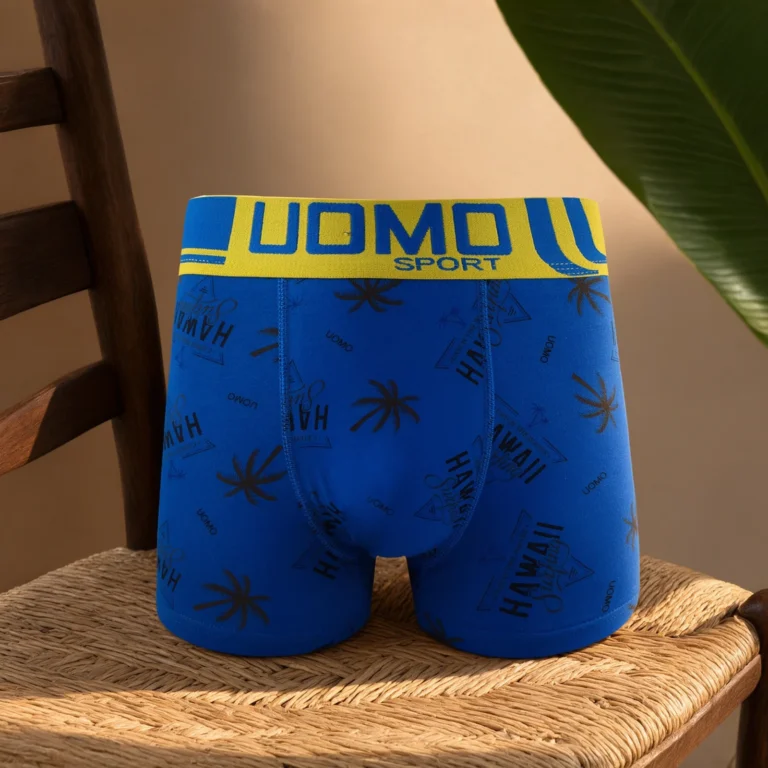 UOMO SPORT Hawaii surf-print cotton boxer brief GMUO-7228AMH on a rattan chair seat, yellow waistband facing camera