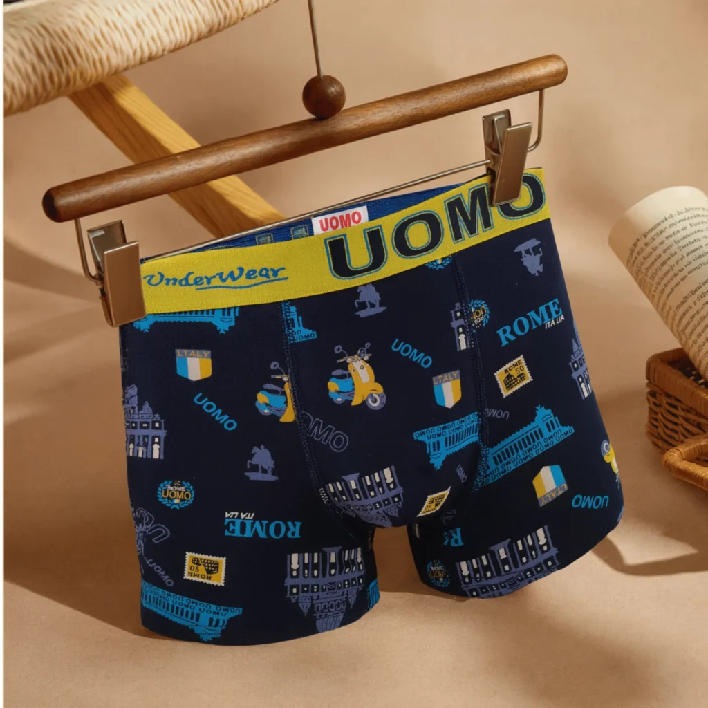 UOMO Rome-print boxer brief GMUO-7330AMH on a wooden clip hanger showing the yellow jacquard waistband